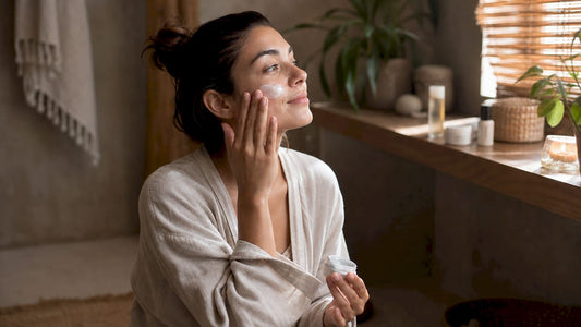 Woman applying CBD skincare cream in bathroom