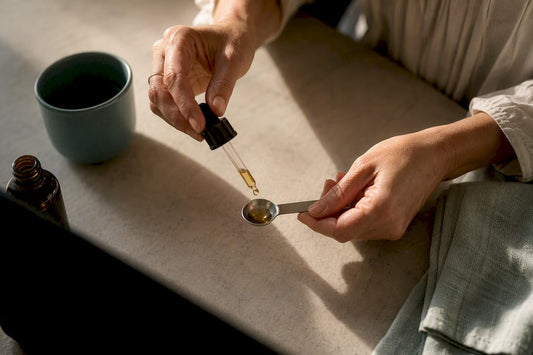 Hand measuring CBD drops carefully